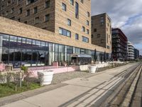 a building with a walkway and lawn area in front of it along a city street