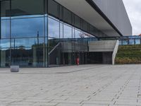 the outside of a building with an open air courtyard in front of it and people walking by the building