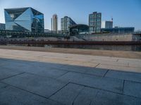 a skateboarder riding on a cement ramp next to a city street under a bridge