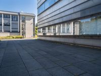 two buildings are visible through a glassy door with blue sky in the background and a bench outside in front