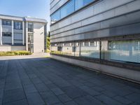 two buildings are visible through a glassy door with blue sky in the background and a bench outside in front