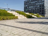 a man riding on top of a skateboard on a stone road near tall buildings