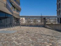 the large office building is located in the center of a cobblestone plaza of the city