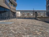 the large office building is located in the center of a cobblestone plaza of the city