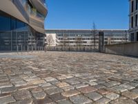 the large office building is located in the center of a cobblestone plaza of the city