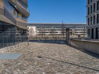 the large office building is located in the center of a cobblestone plaza of the city