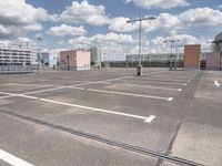 this is an empty parking lot with several buildings in the background and many streetlights