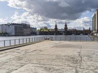 a person sitting on a bench looking out at the water with a bridge in front of it