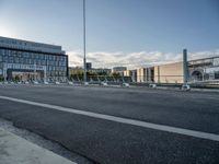 view of the entrance to a building, from a distance, with the street side of the parking lot and the bridge in the foreground