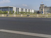 a young man rides his bike past the parliament building in berlin, germany by himself