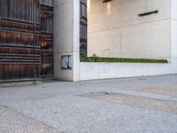 a red fire hydrant sitting next to a building and door way with planters and wooden paneled wall