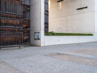 a red fire hydrant sitting next to a building and door way with planters and wooden paneled wall