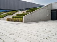 a photo of a skateboarder in a concrete parking lot with stairs and landscaping