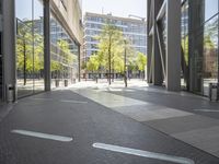 empty walkway in an outdoor area, with people walking along the side walk and on the sidewalk