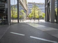 empty walkway in an outdoor area, with people walking along the side walk and on the sidewalk