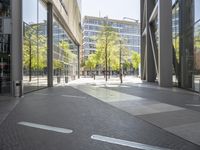 empty walkway in an outdoor area, with people walking along the side walk and on the sidewalk