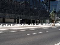 the empty street near the building is lined with white pillars and fenced streets in front