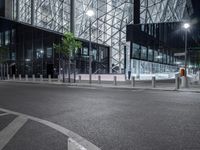 a very pretty building with a big glass front by some light poles on a city street