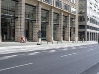 several bicycles are parked near the edge of a busy street next to a building,