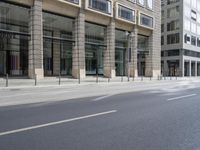 several bicycles are parked near the edge of a busy street next to a building,