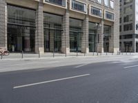 several bicycles are parked near the edge of a busy street next to a building,