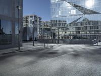 a building with glass and a sky background at the corner of the street in front of it is a traffic light and some windows