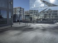 a building with glass and a sky background at the corner of the street in front of it is a traffic light and some windows