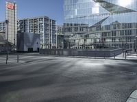 a building with glass and a sky background at the corner of the street in front of it is a traffic light and some windows