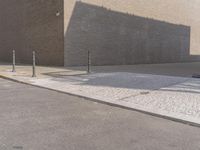 a brick building that is on a street corner next to a concrete curb with parking meters attached to it