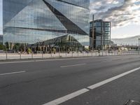 there is a bench along with a large building on it, reflecting in the glass windows