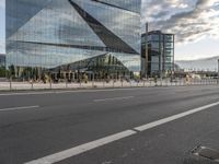 there is a bench along with a large building on it, reflecting in the glass windows