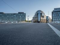 two roads in front of a large building with lots of windows on either side of it