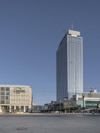 a very tall office building with a clock tower in it's center of a city square