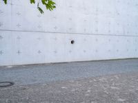 an open fire hydrant in front of a large white wall with crosses on it