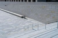 a view of the steps leading up to a building from the ground with a rail and stairs