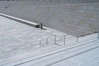 a view of the steps leading up to a building from the ground with a rail and stairs