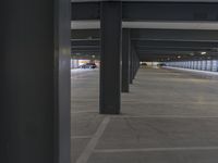 a parking garage with two black and one white vehicles parked outside the doors on each side