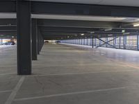 a parking garage with two black and one white vehicles parked outside the doors on each side