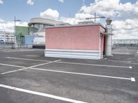 a small building with a lot of windows on top of it is in a parking lot