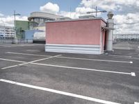 a small building with a lot of windows on top of it is in a parking lot