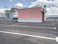 a small building with a lot of windows on top of it is in a parking lot