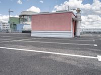 a small building with a lot of windows on top of it is in a parking lot