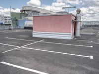 a small building with a lot of windows on top of it is in a parking lot