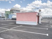 a small building with a lot of windows on top of it is in a parking lot