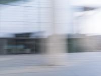 a blurry image of a man riding a skateboard on the road using motion blurred