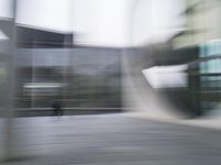 a blurry image of a man riding a skateboard on the road using motion blurred