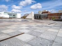 a stone slab with an empty building in the background and a white wall behind it