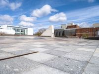 a stone slab with an empty building in the background and a white wall behind it