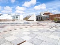 a stone slab with an empty building in the background and a white wall behind it