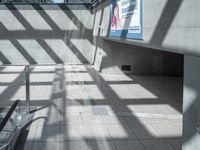 a hallway is seen through a glass door, with a ramp in the background and a bench along the wall